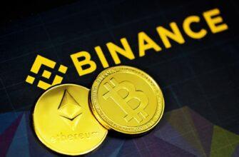 two gold bitcoins sitting next to a binance sign