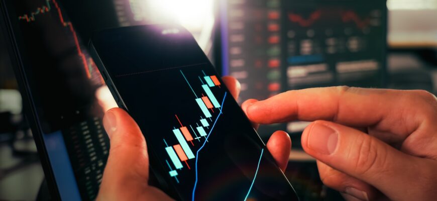 Hands holding smartphone showing stock market data